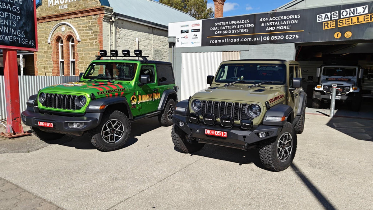 Two Jeep Wrangler Rubicons with 4x4 accessories outside the Roam Offroad shop