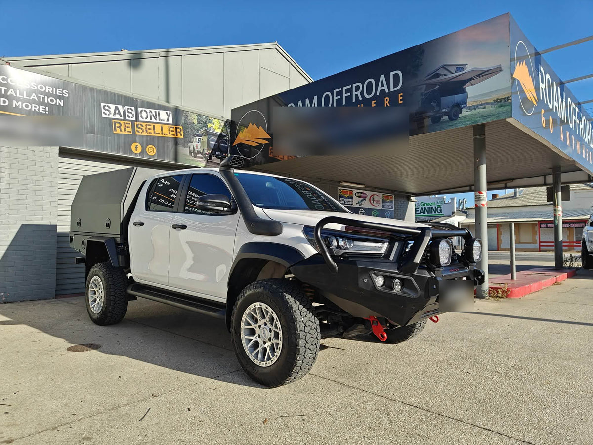 White dual-cab ute with a Hamer bull bar, canopy and snorkel outside the shop