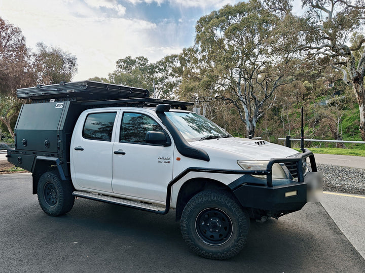 The Hilux touring setup parked by gum trees