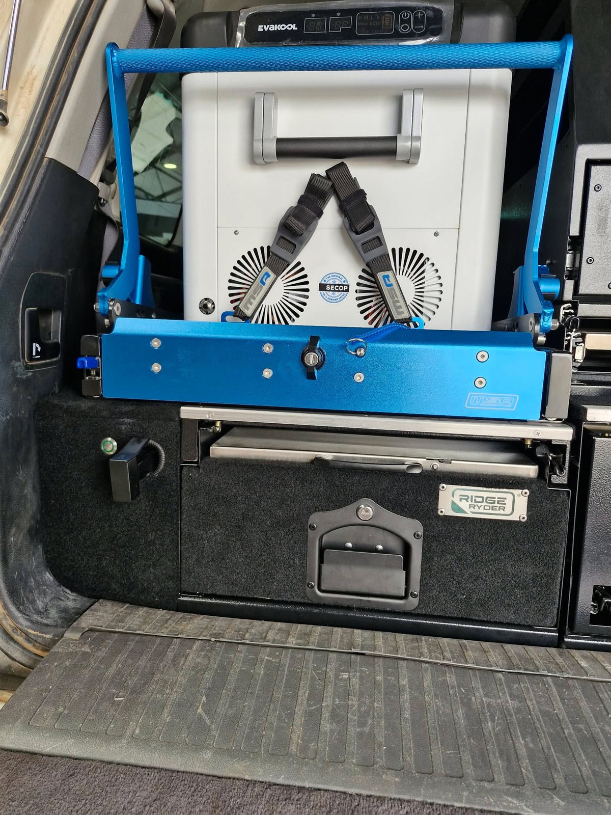 Fridge strapped onto a blue fridge slide above the drawer